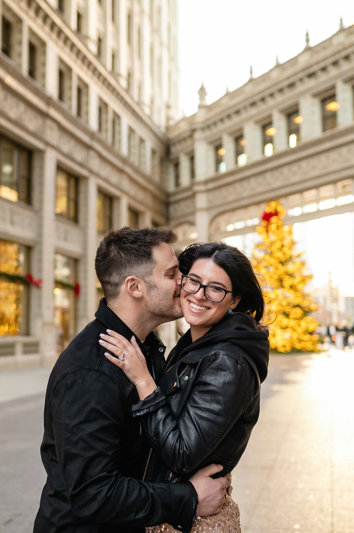 A man kisses a women during Christmas time at the Wrigley Building in Chicago