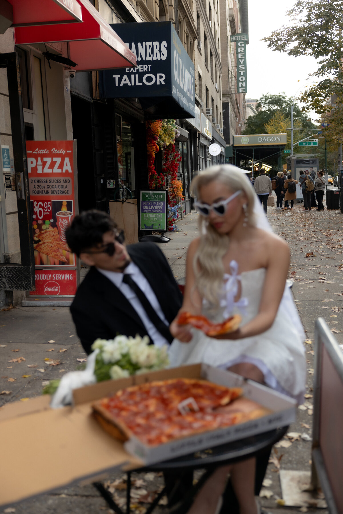 Candid shot of the couple laughing together at a table in a classic NYC pizza shop.