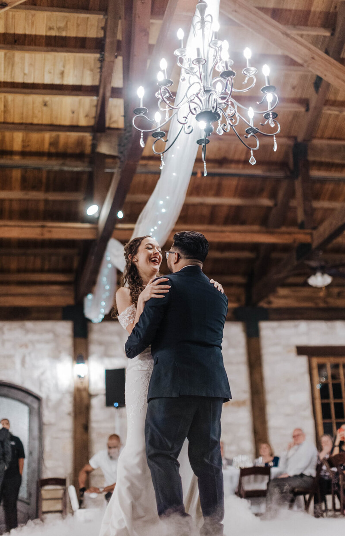 Bride and groom sharing their first dance under a chandelier at a Central Florida wedding venue.