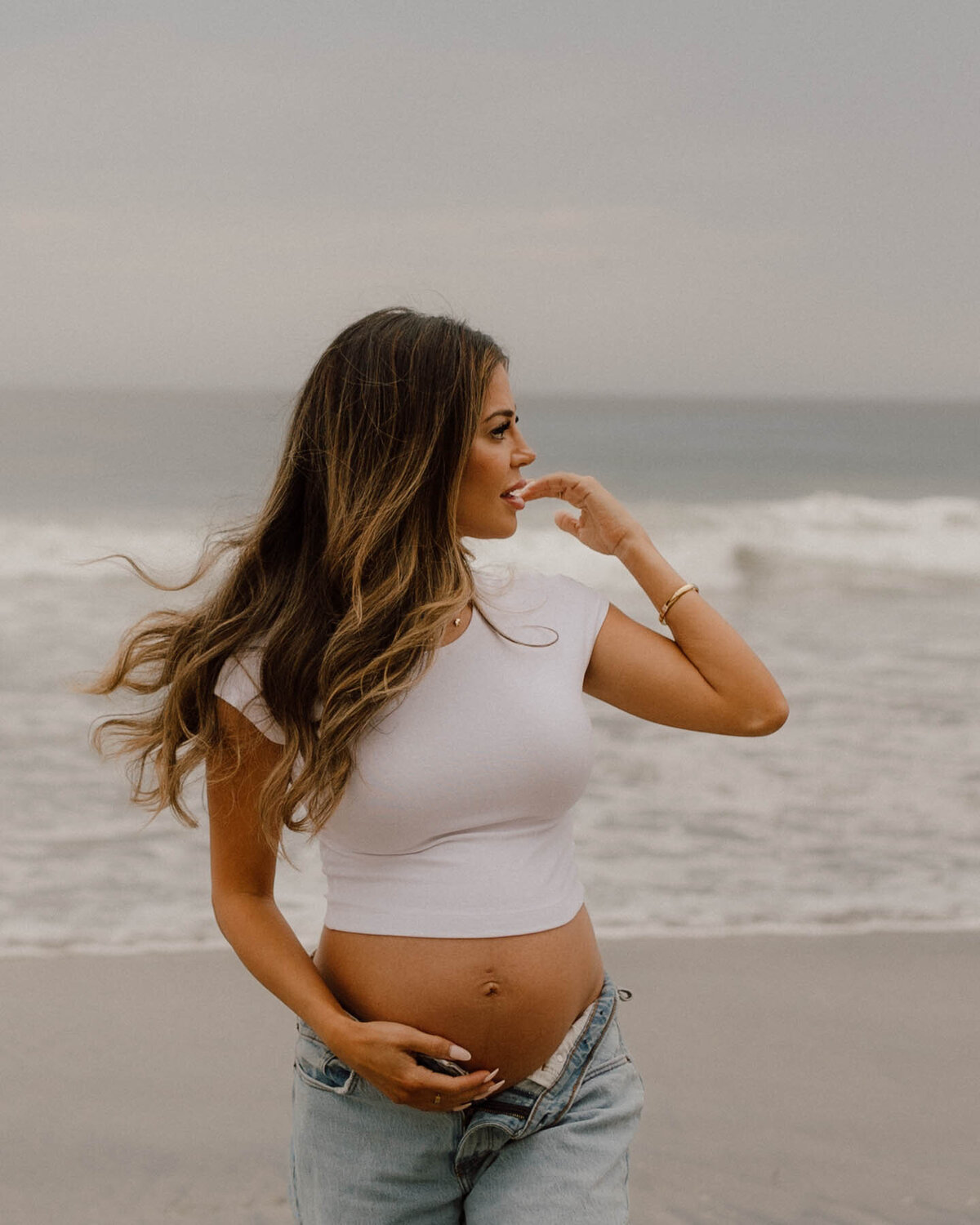 mama to be holding an ultrasound photo with husband against belly