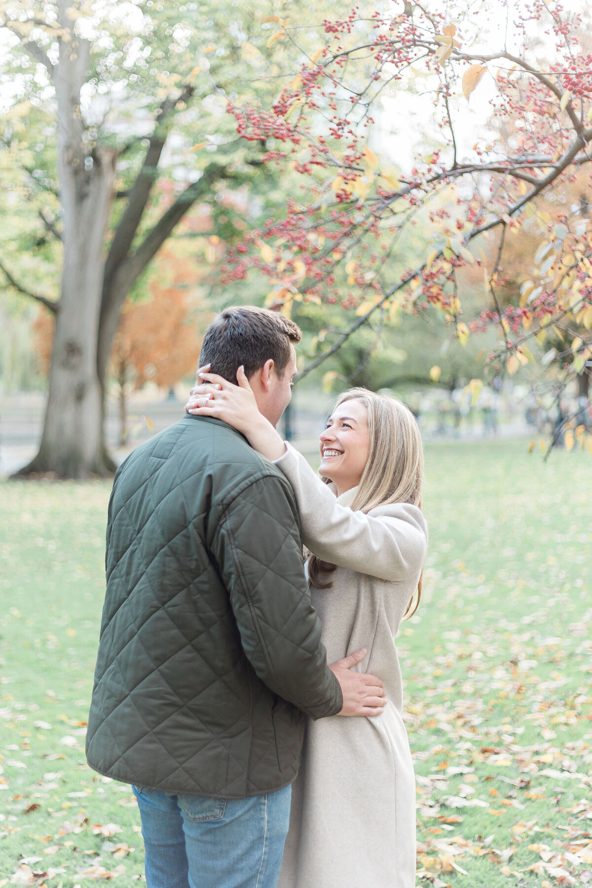 An engaged couple share a moment together in the BOston Public Garden