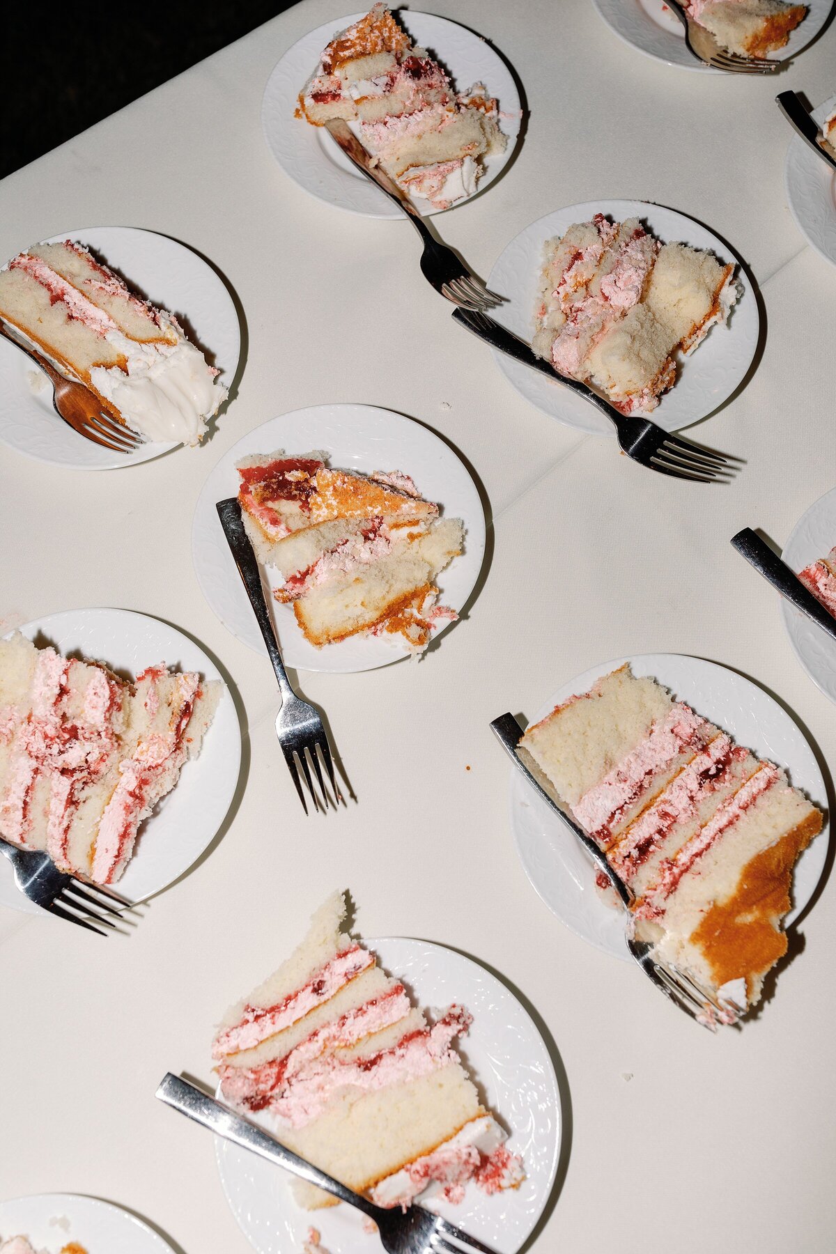 Slices of wedding cake with strawberry filling covering table