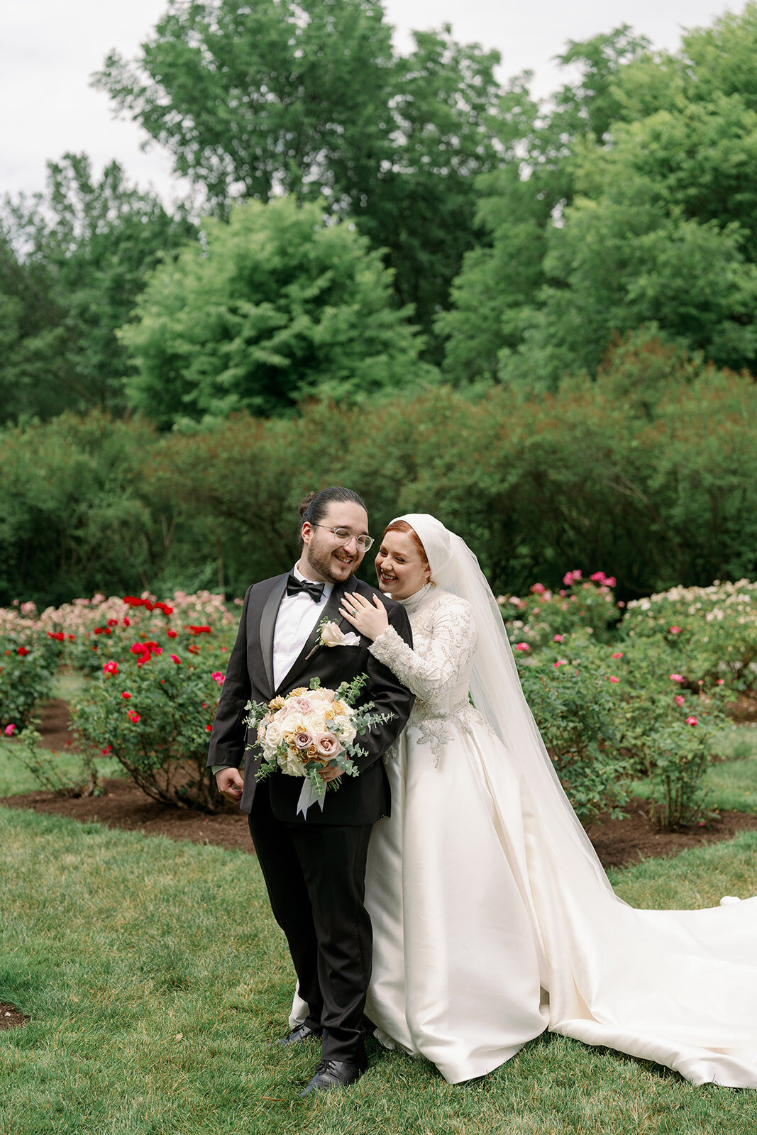 Bride and groom posing by the iconic wrought iron gate at Henry Ford Estate in Dearborn Michigan for timeless wedding photos.