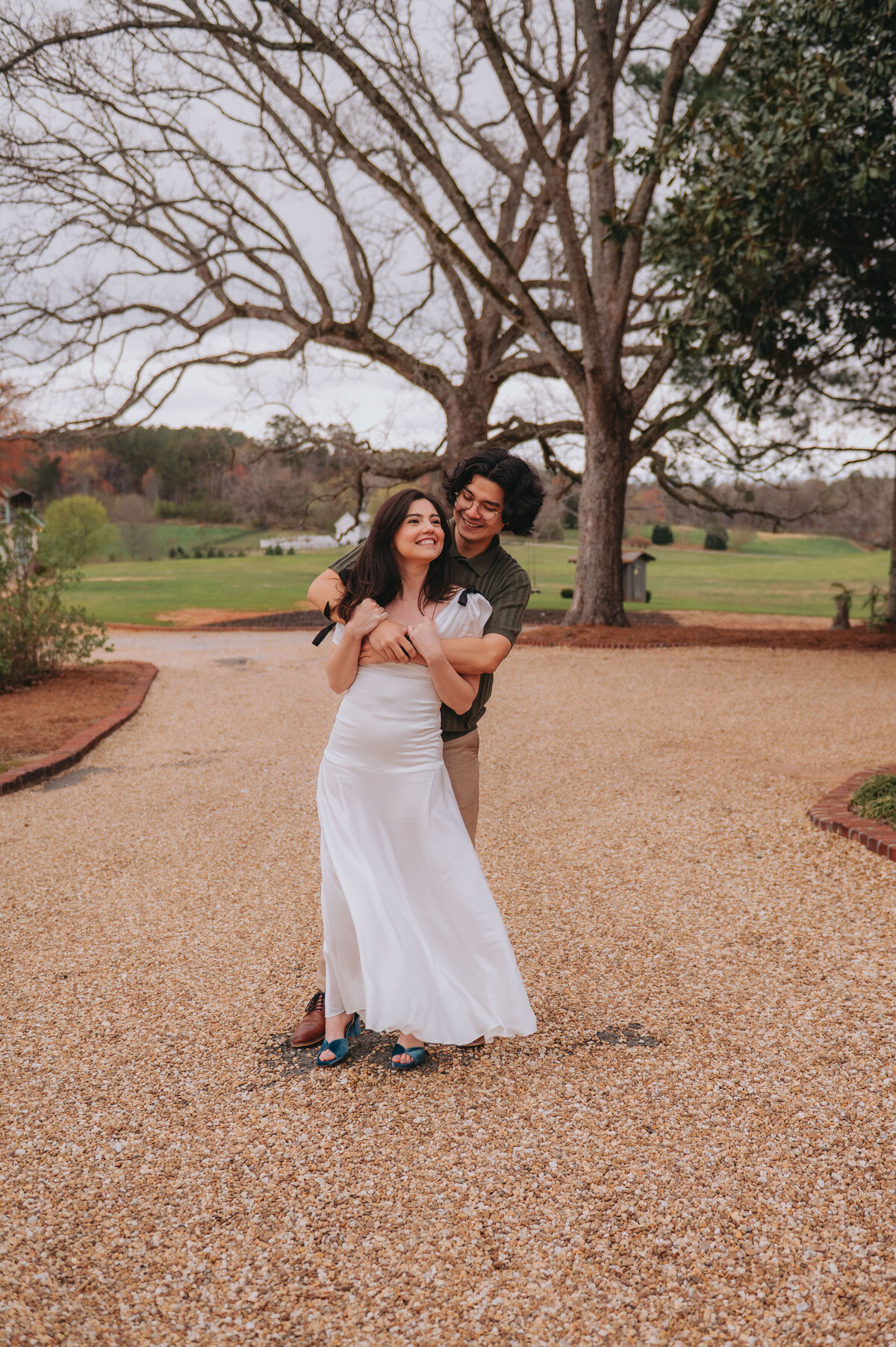 A couple smiles happily outdoors