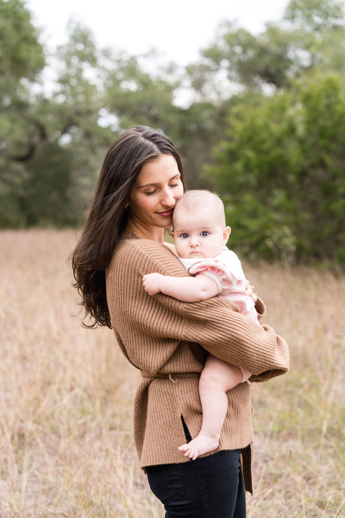 Family plays during a family photoshoot at Circle C Park in Austin, Texas.