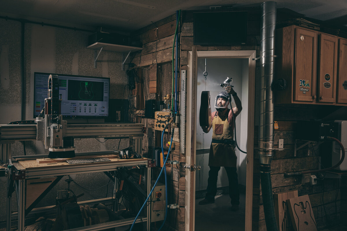 A person spray painting something in a workshop