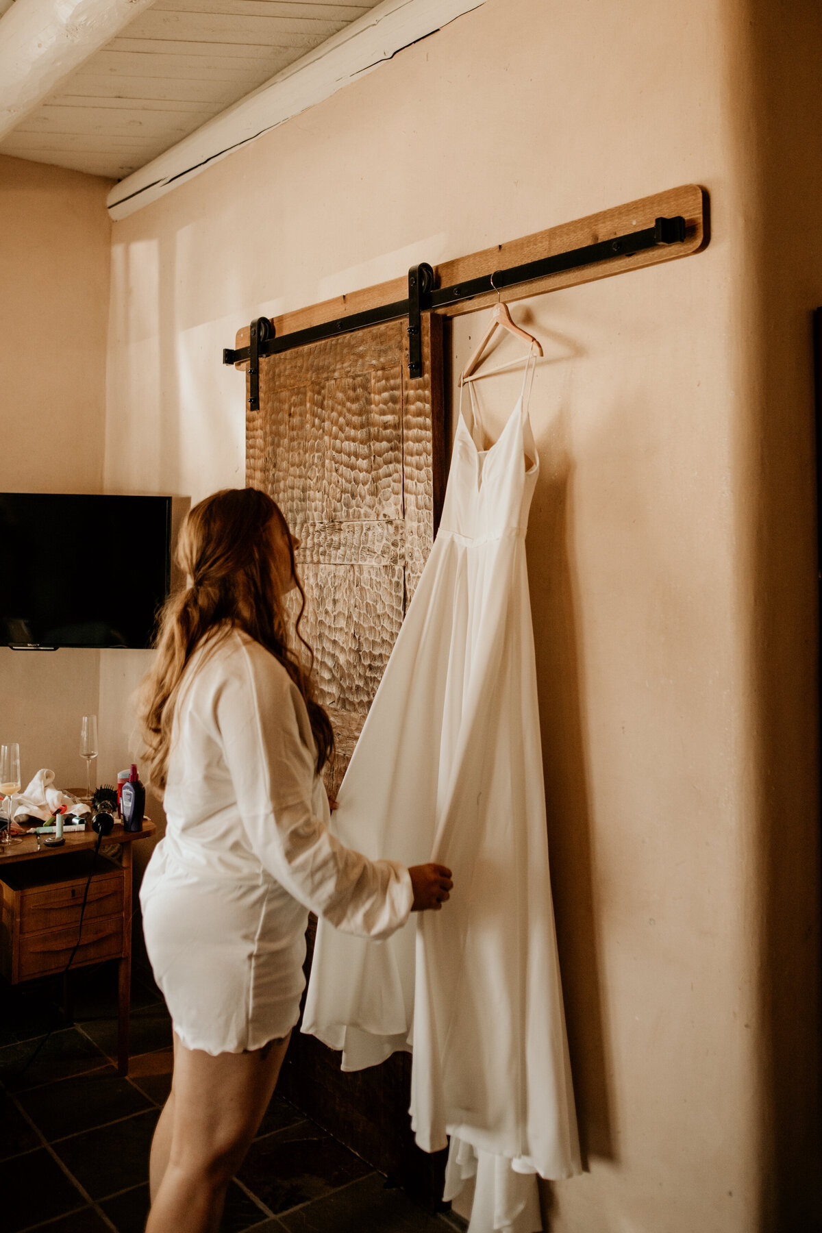 bride admiring bridal gown before getting ready