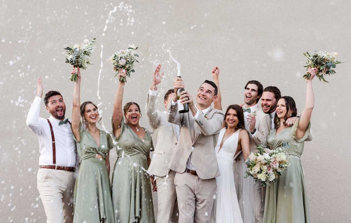 Energetic bridal party celebrating with champagne at Factory 51 wedding venue — candid moment by Brisbane wedding photographer.