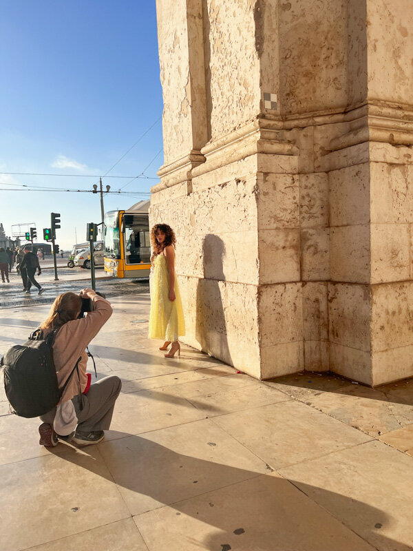 Female photographer working with a model who is wearin a dress on a sunny day