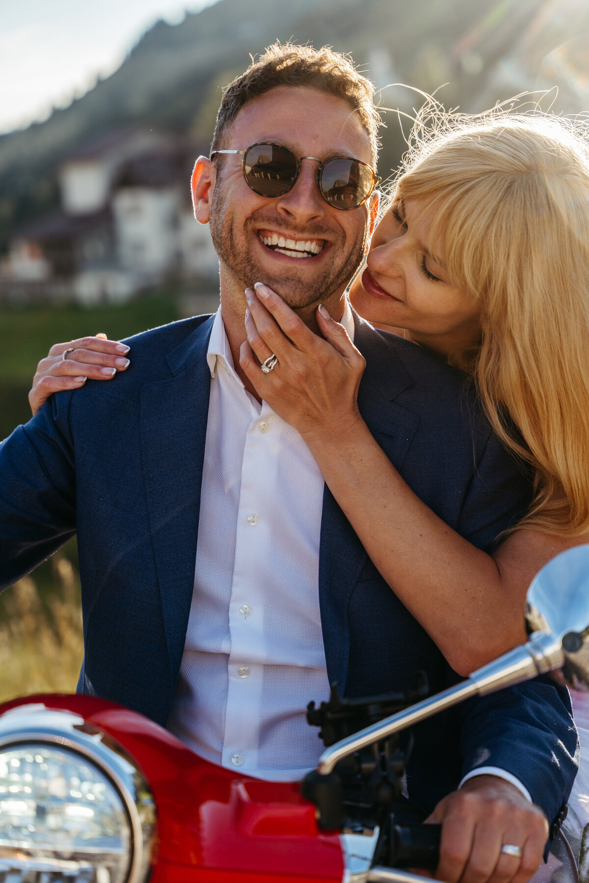Couple riding Vespa at Passo Gardena during golden hour