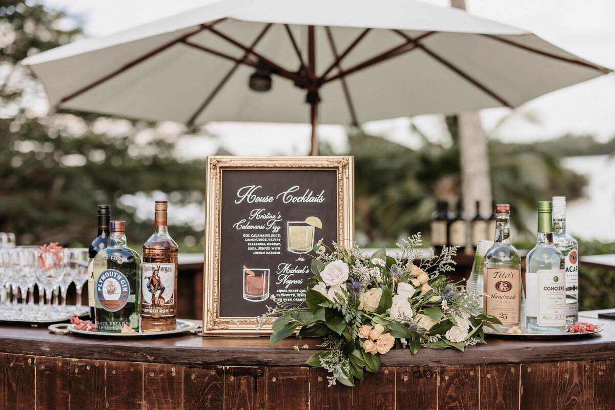 Dark wood bar with bar sign and specialty drinks and umbrella