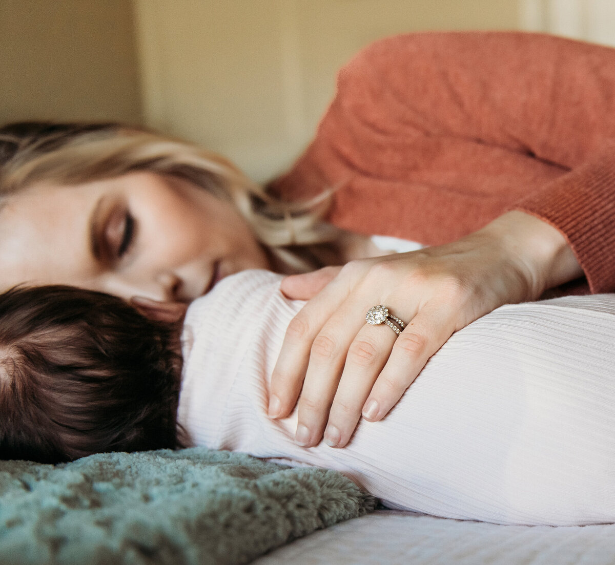 Newborn Photographer, Mom sleeping next to baby with her hand on baby's back.