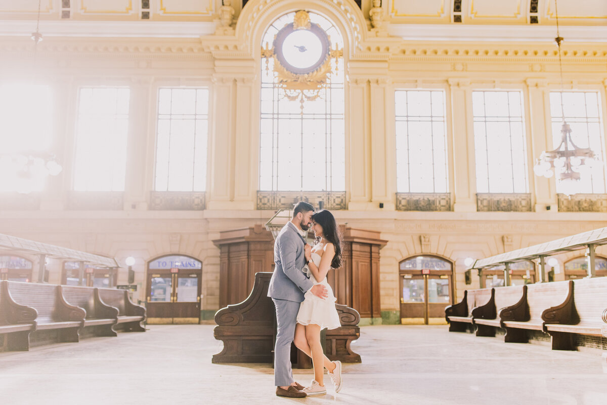 A couple share a moment inside the lackawanna nj transit metro station waiting area during their engagement session in hoboken