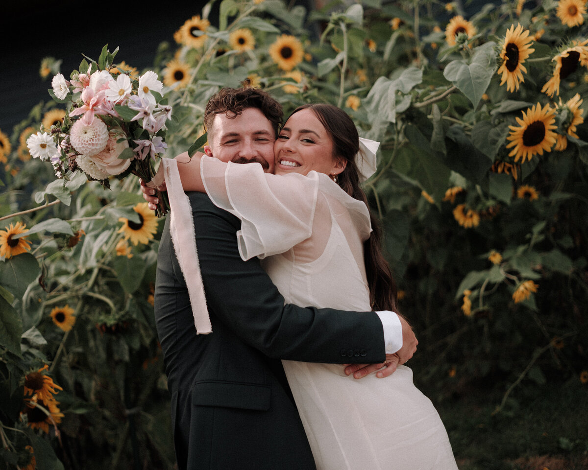 sunflowers surround happy bride and groom embracing each other