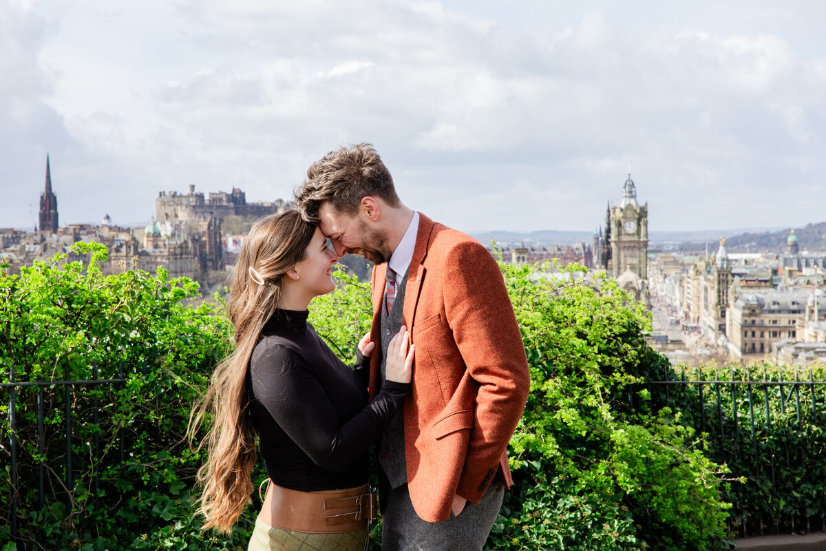 bride and groom smiling at eachother with the skyline behind them