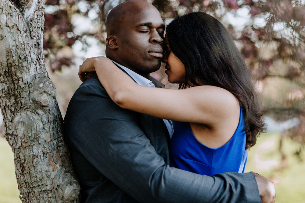 Bride and groom holding hands looking at each other while standing in front of rolling hills with the sunlight coming down on them