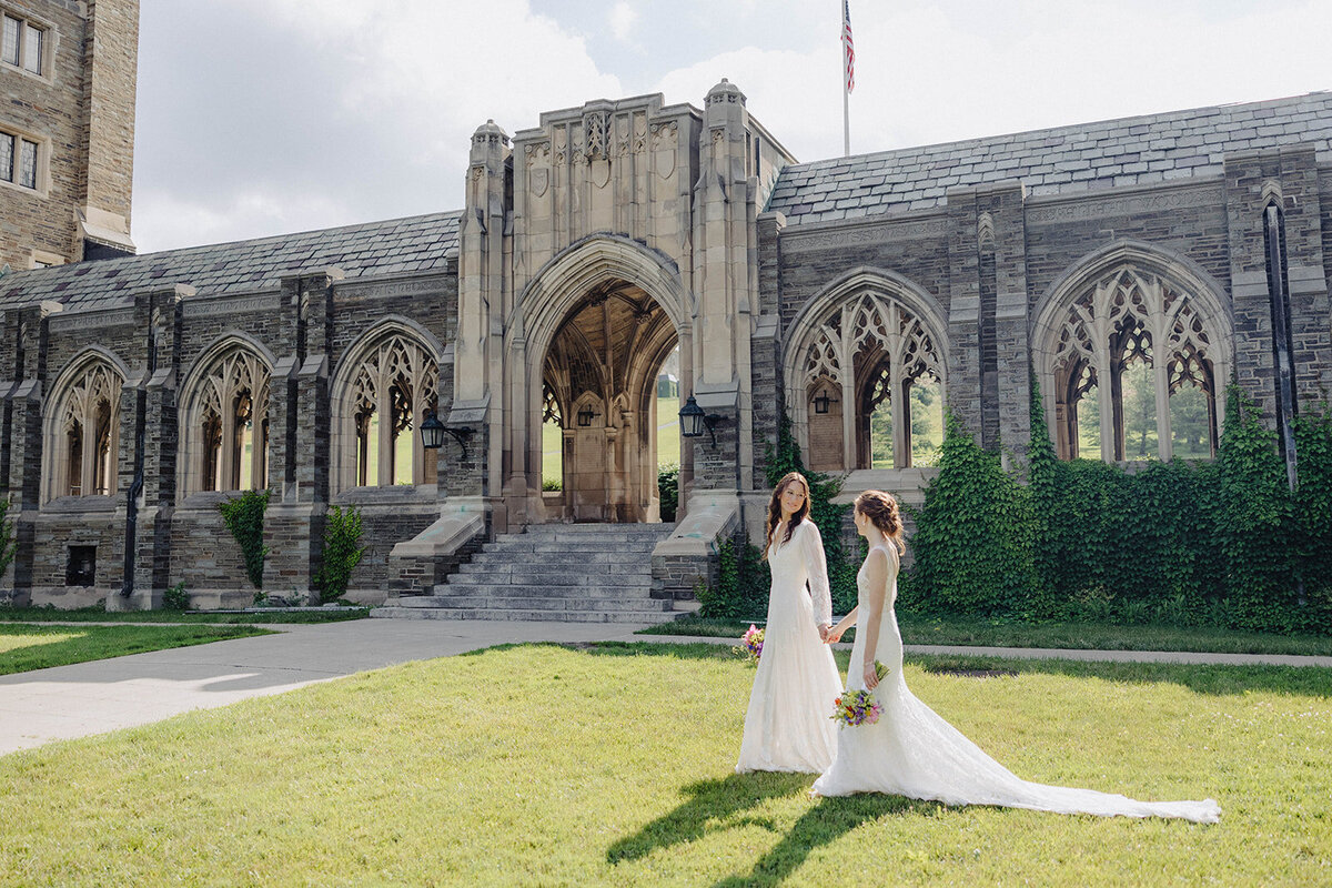 Brides holding hands walking along at Cornell University wedding