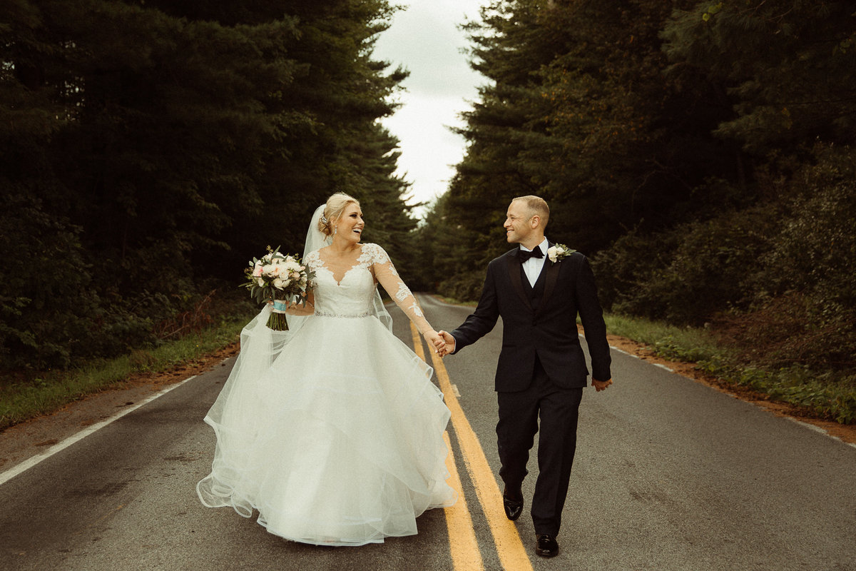 bride and groom walking down road holding hands in Baldwinsville, NY