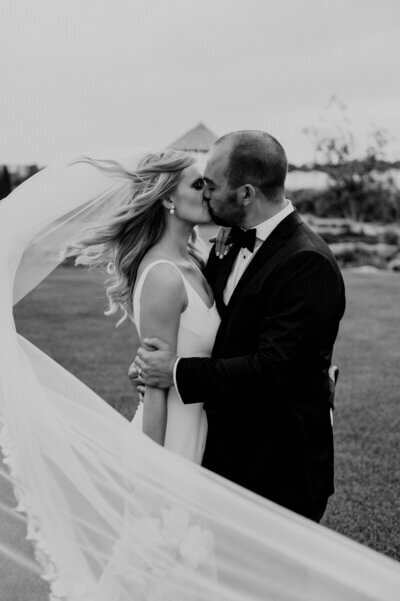 Bride and groom kissing with veil flying to show planning a wedding in chicago