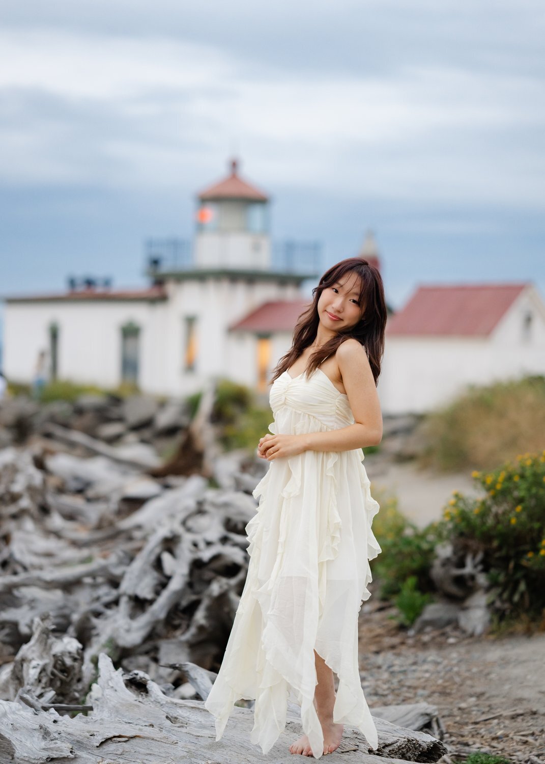 lighthouse senior girl standing at sunset