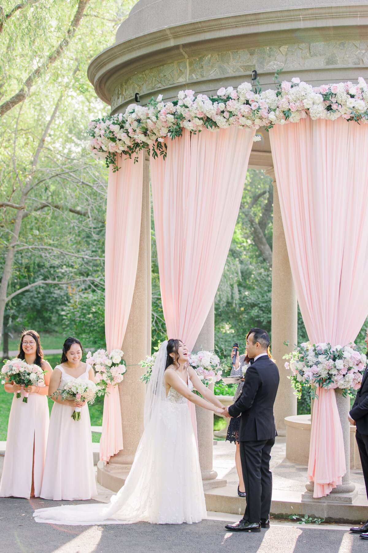 Bride and groom holding hands and laughing during their Boston wedding ceremony