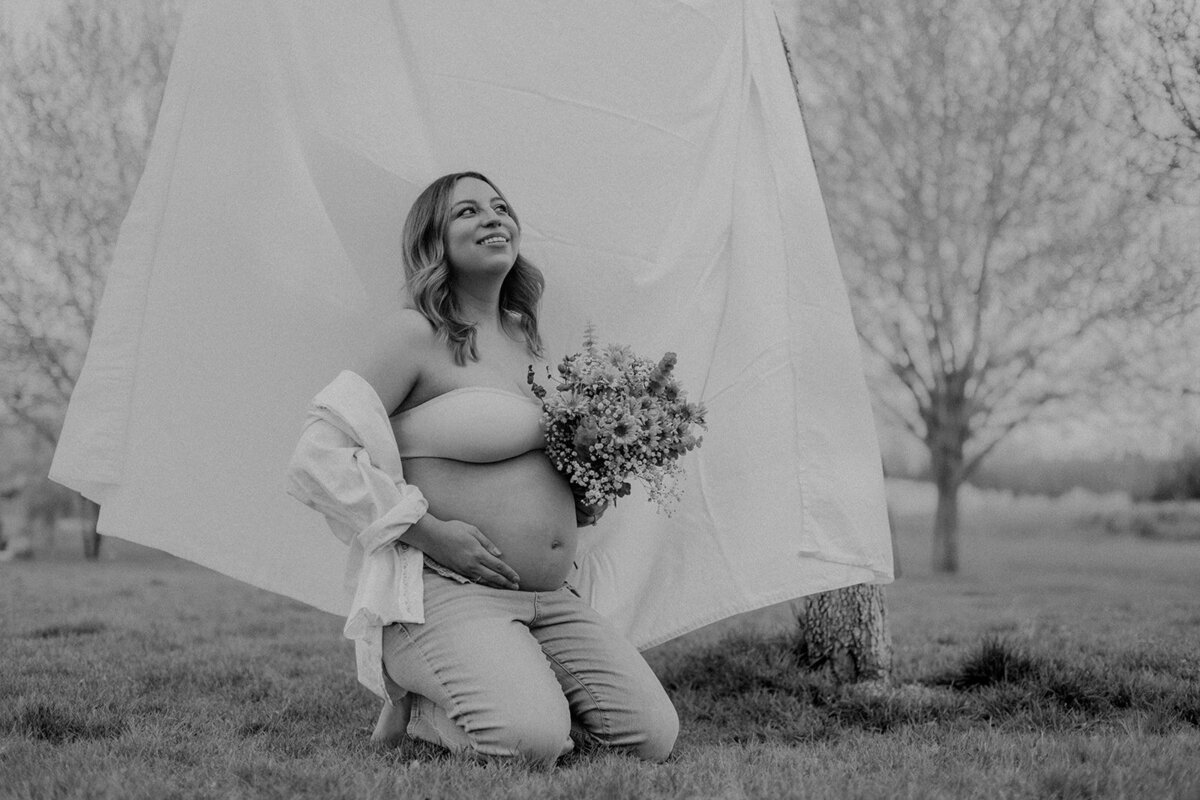 A pregnant woman is happy while holding her belly