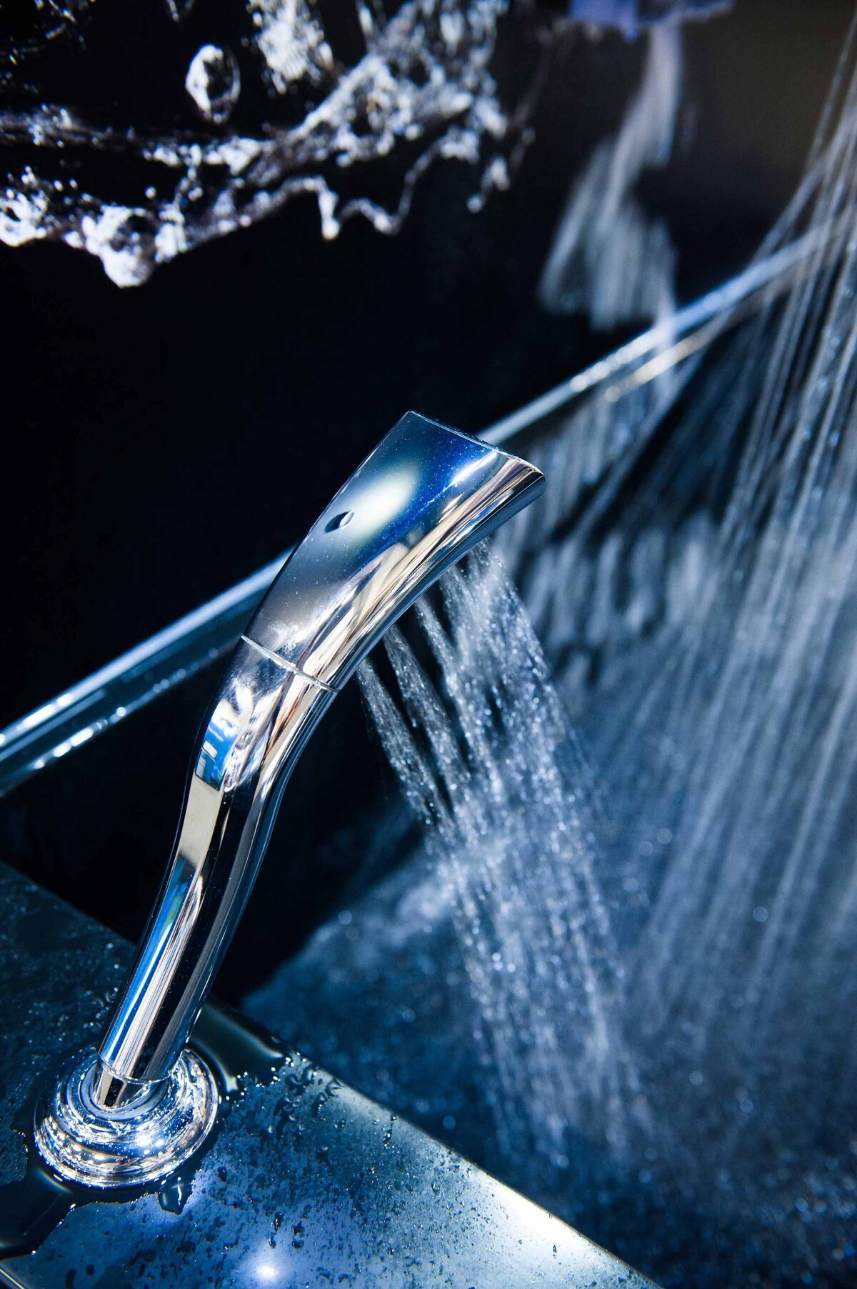 A sleek and modern silver faucet sprays water at a display booth