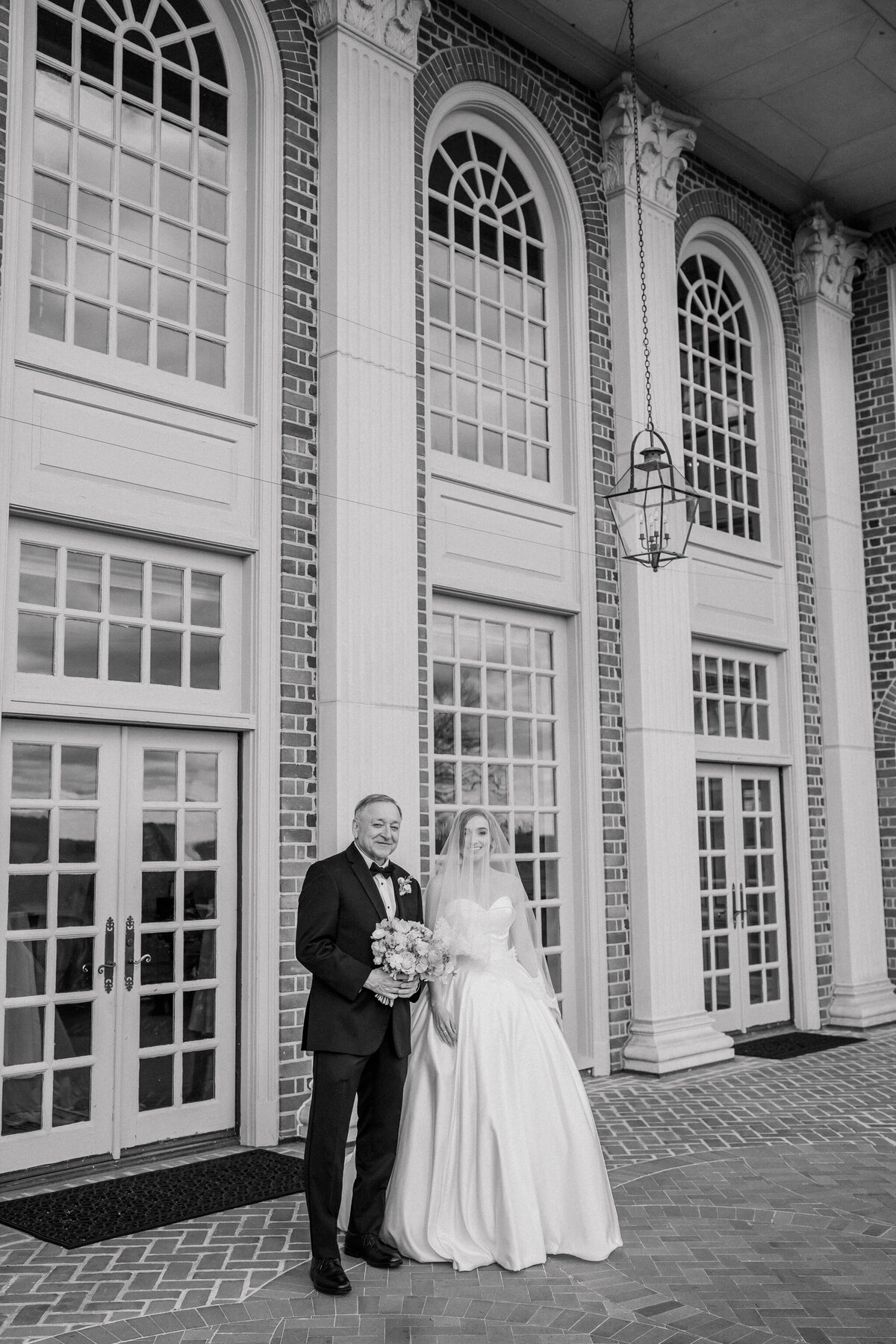 Wedding at the Estate at River Run in Maidens, VA | Wedding Photographer in Richmond | black and white image of bride and her dad on the brick terrace of the Estate at River Run wedding venue in Richmond ready to walk down the aisle for the ceremony