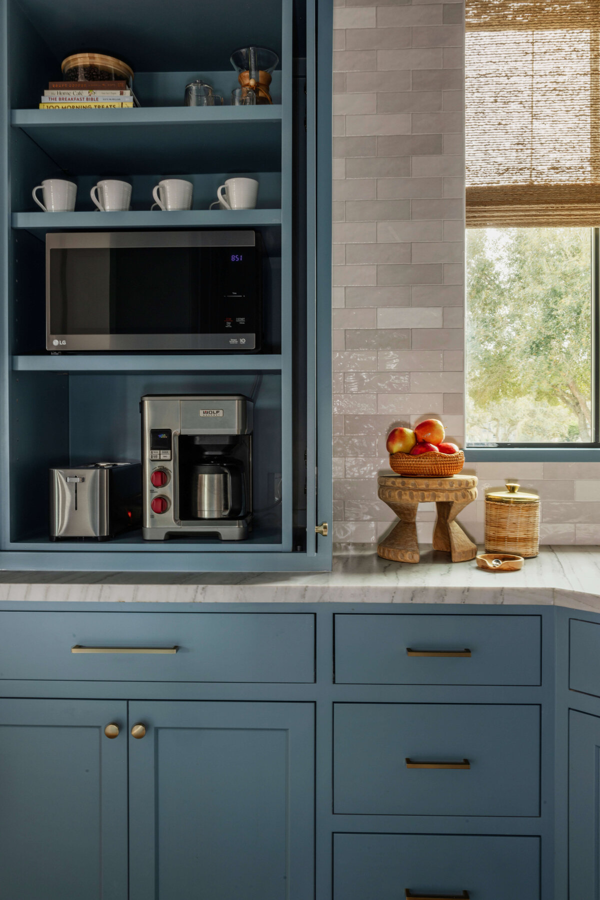 oyster creek studios missouri city new build dark blue shelving in kitchen and gray tile by window