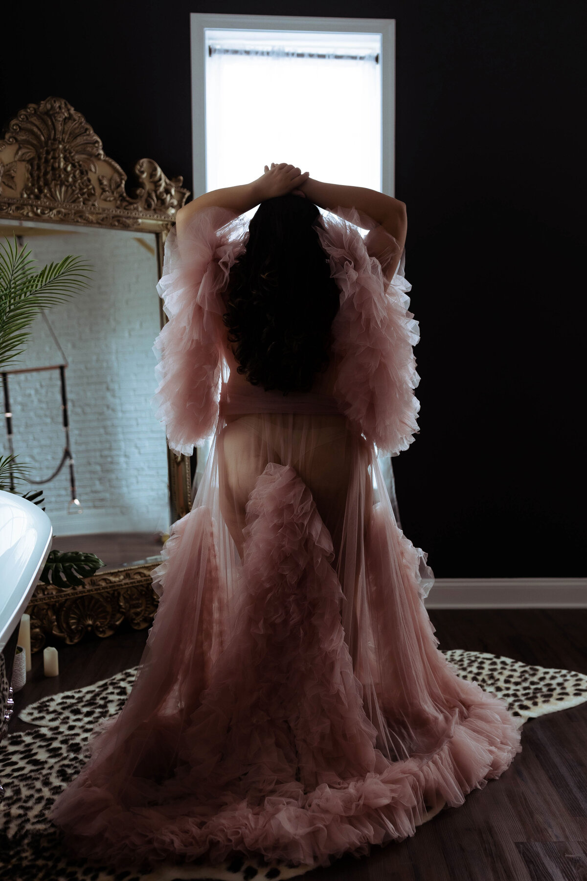 standing woman wearing luxury tulle robe during boudoir session