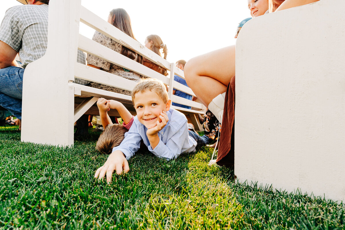 Little boys laying on grass during wedding ceremony at Cattle Springs in Arlee, MT
