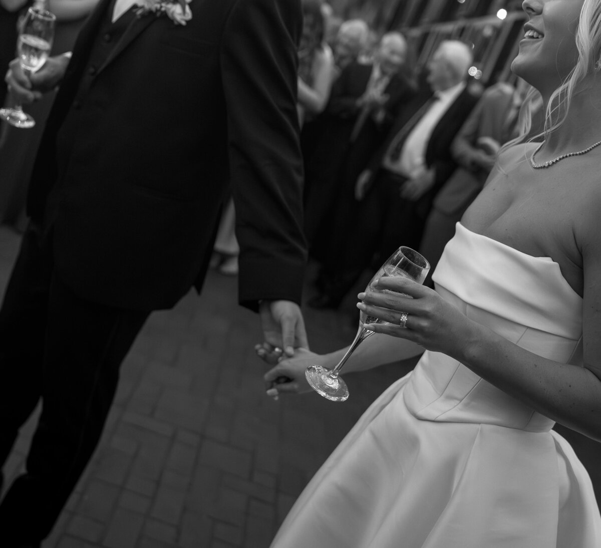 Detail shot of couple holding hands with champagne by film wedding photographer