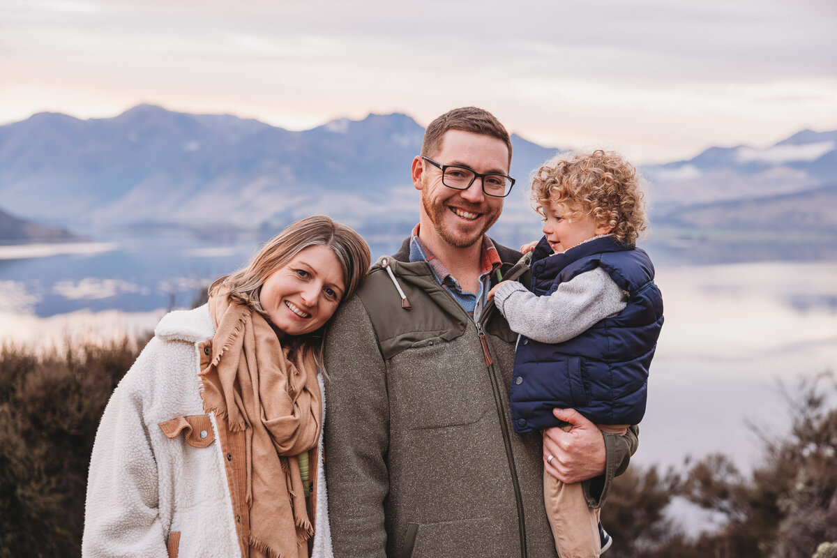 family posing with lake and mountains in the background during a wanaka family photography session