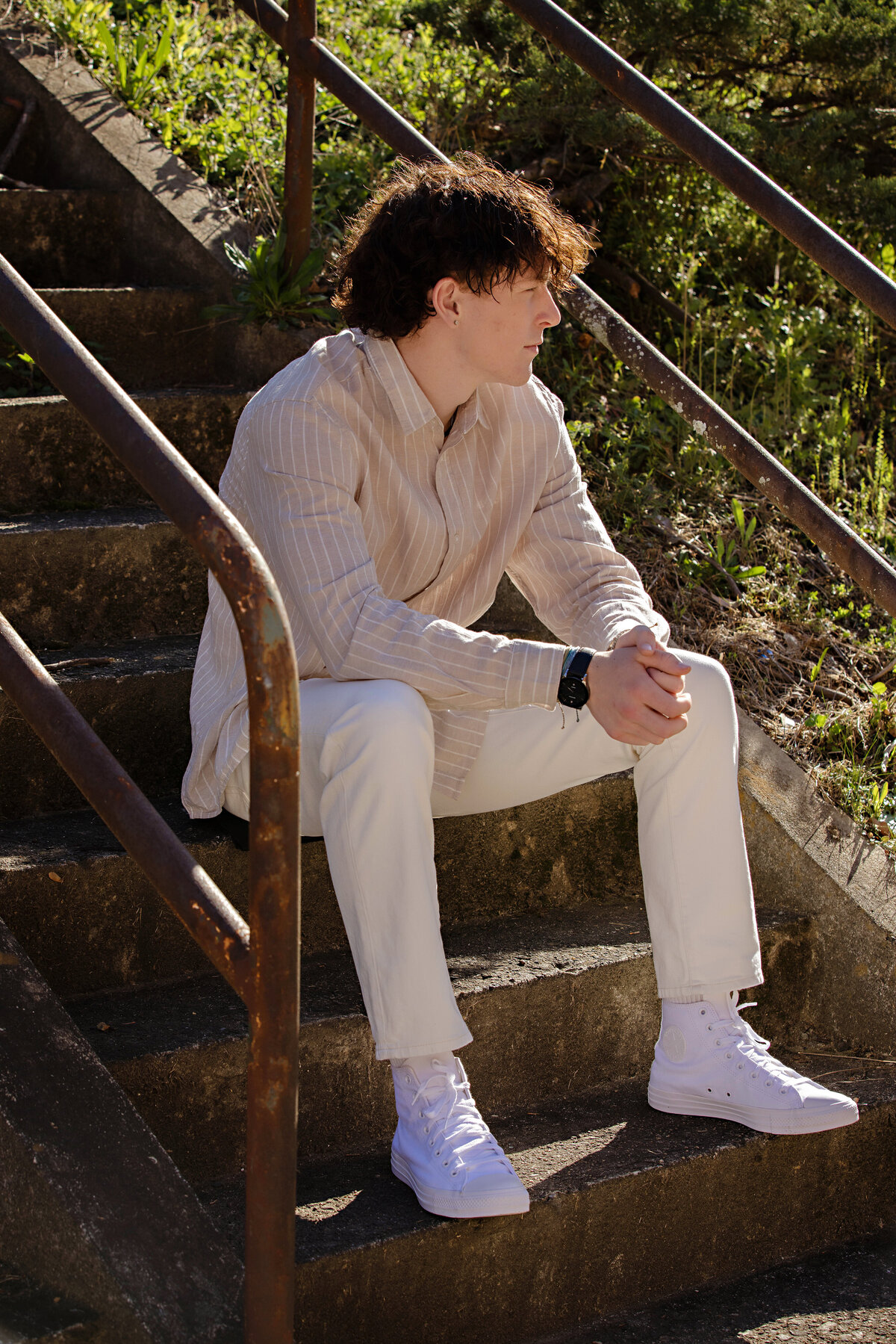 Confident pose of high school senior, captured by Charlotte photographer on an industrial old staircase