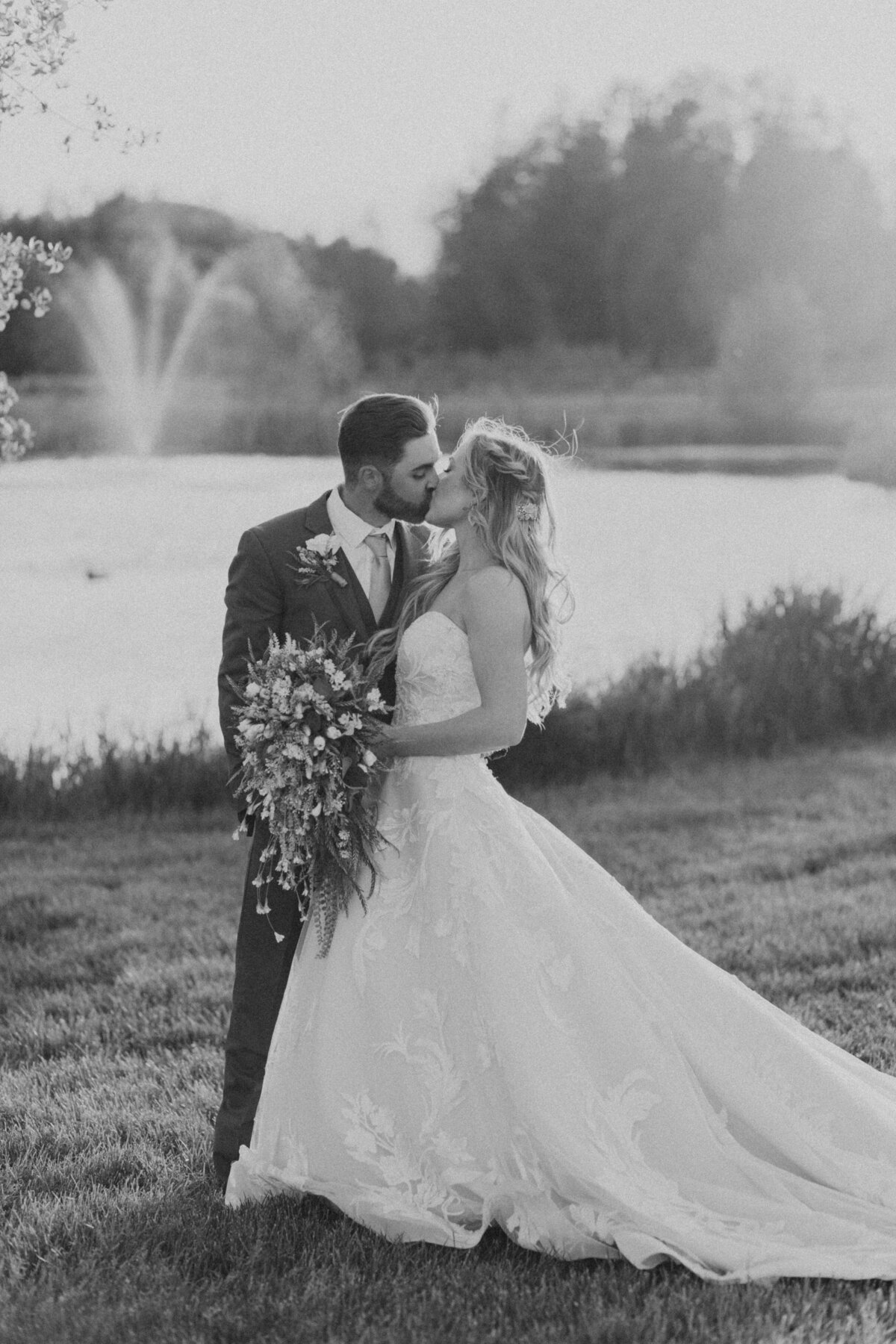 black and white image bride and groom by lake