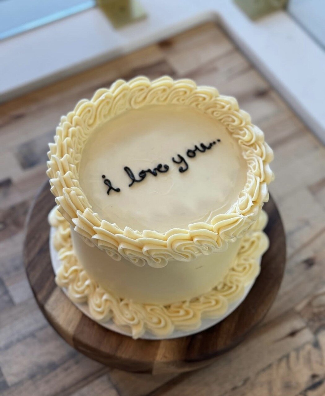 Gluten-free buttercream cake with piped yellow frosting and the words “I love you” on top, handcrafted at Grain Artisan Bakery in Snohomish, WA.
