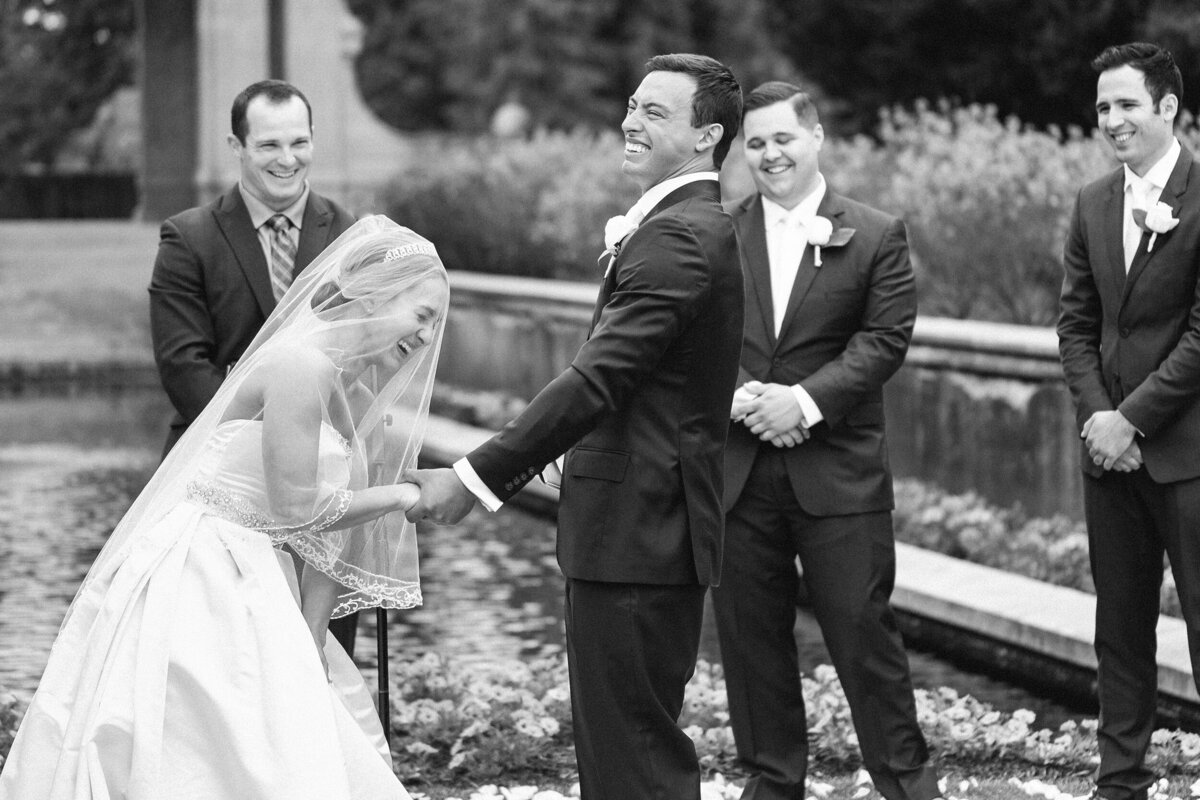 Black and white photo of Bride and groom laughing during their wedding ceremony