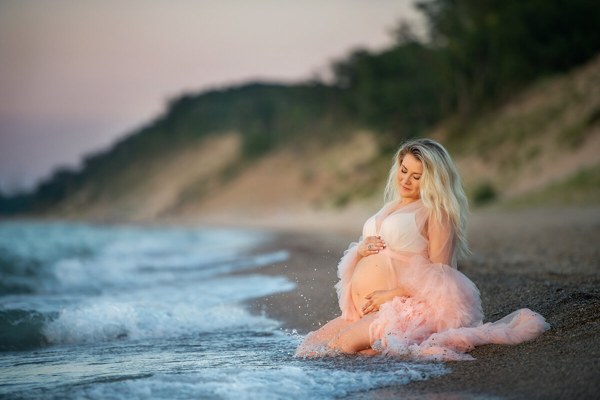 Pregnant woman on the sand with pink maternity dress in Indiana dunes  beach