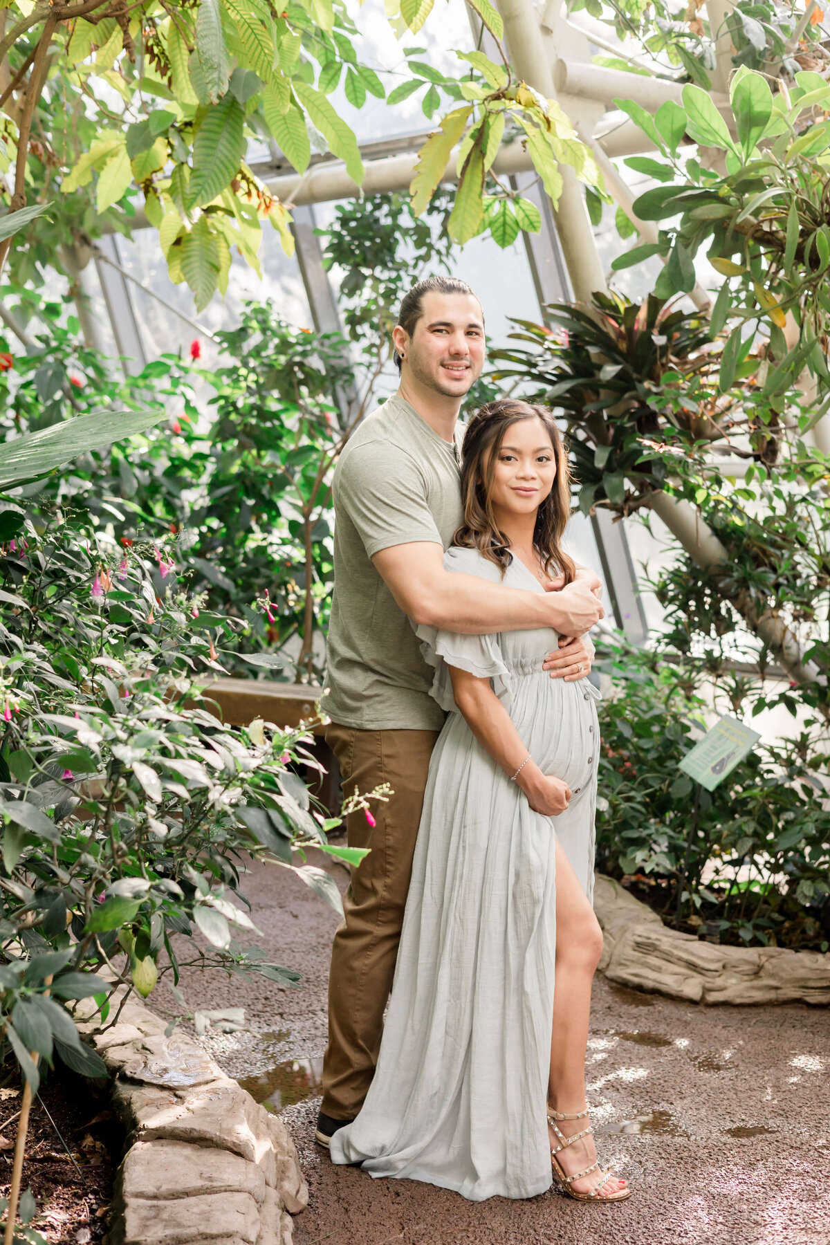 a pregnant couple surrounded by plants