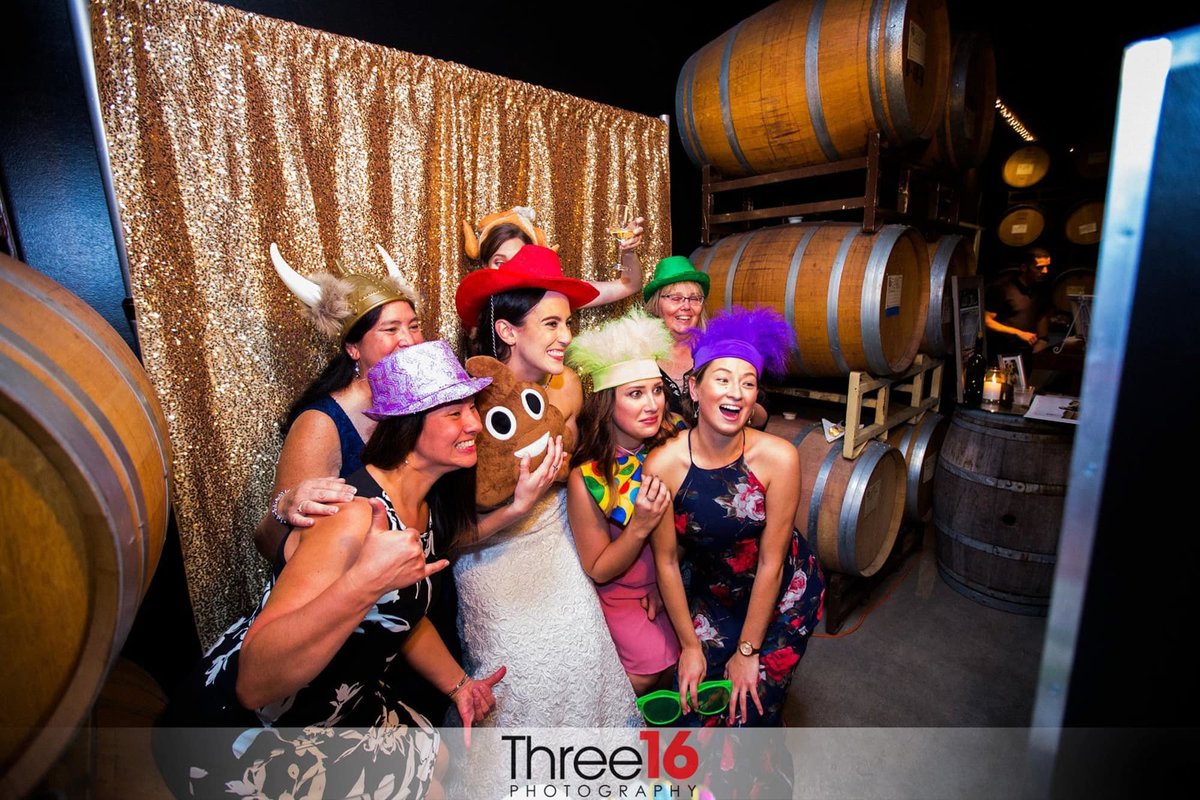 Bride and her wedding guests have lots of laughs in an open air photo booth during the wedding reception