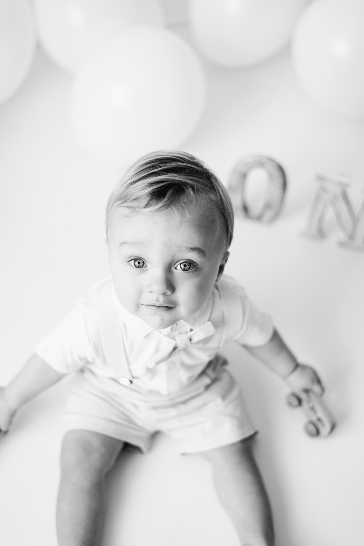 baby boy looking up at the camera in billingshurst cake smash photoshoot