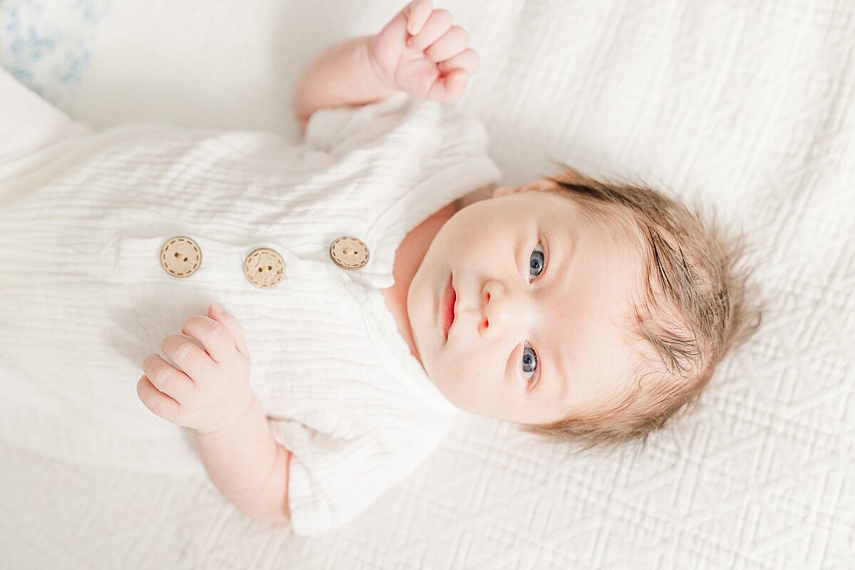 baby lays on bed dung in-home newborn photo session with Sara Sniderman Photography in Needham Massachusetts