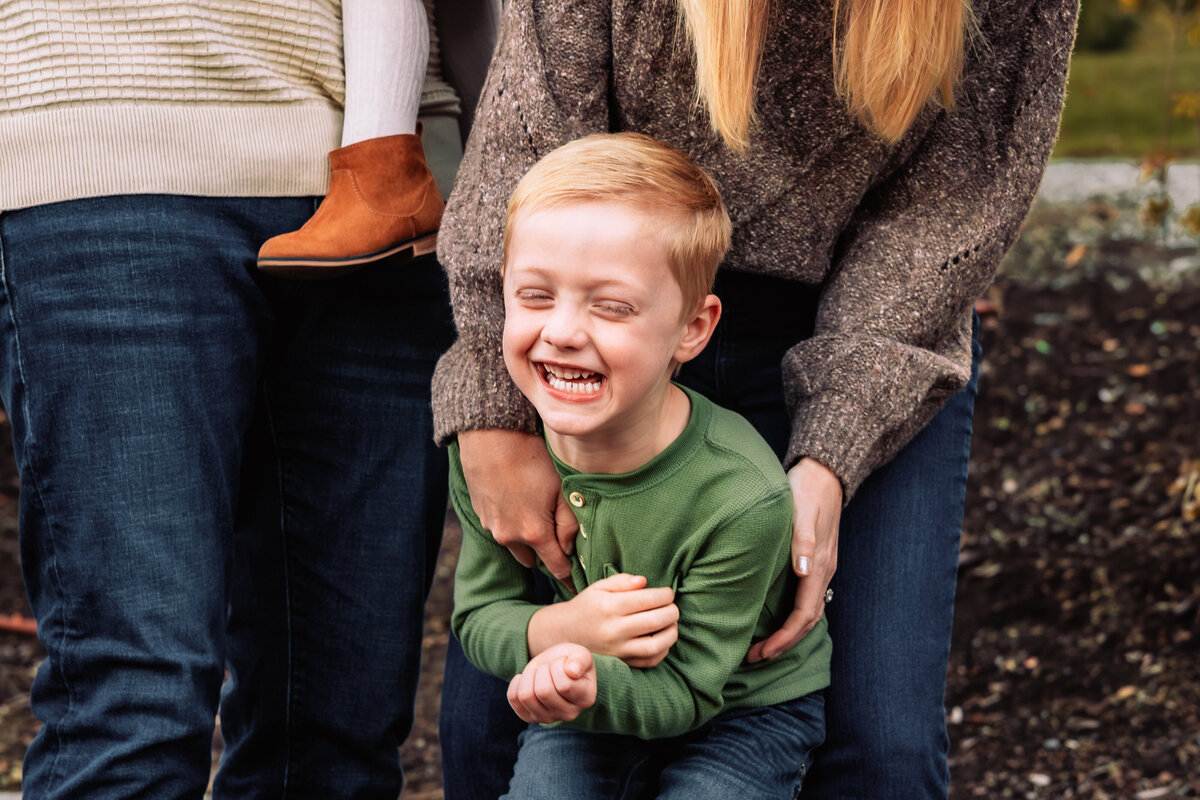 son-laughing-with-parents-hands