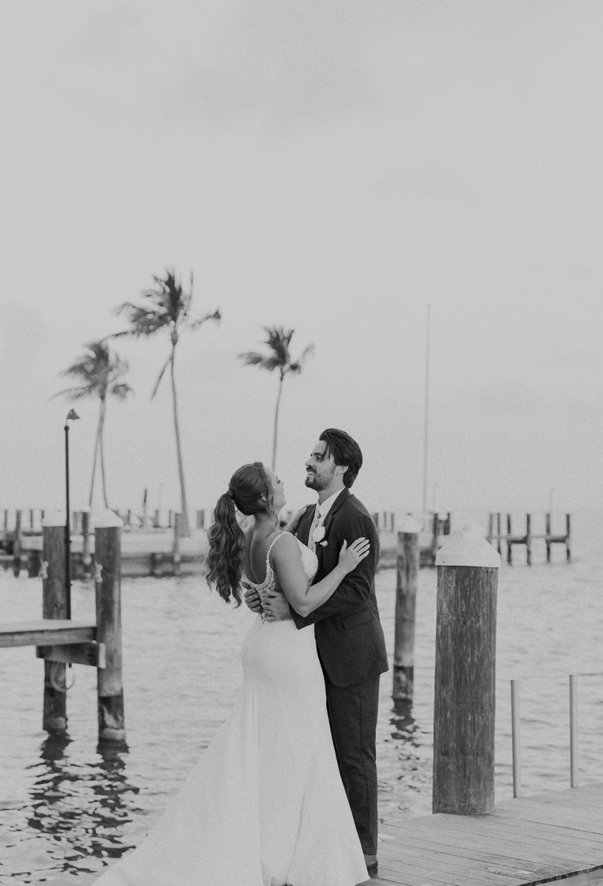 Bride and groom sharing a tender moment on the dock at Miami, captured by Claudia Amalia, a wedding and lifestyle photographer based in Miami and Florida Keys, South Florida. Destination weddings available. Portfolio highlight.