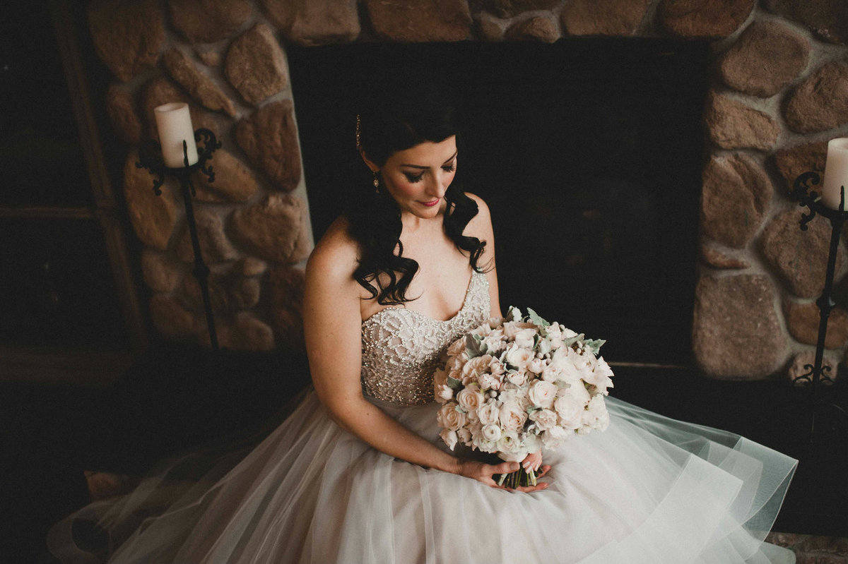 Stunning bride holding white and grey bridal bouquet.