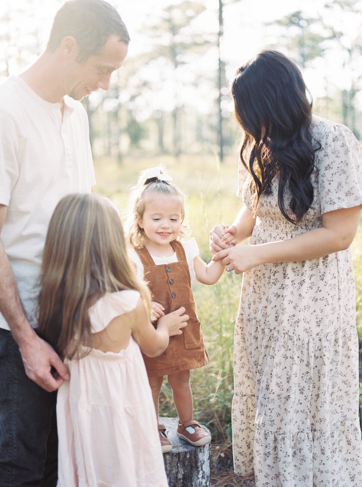 family tickling toddler in field by Orlando family photographer
