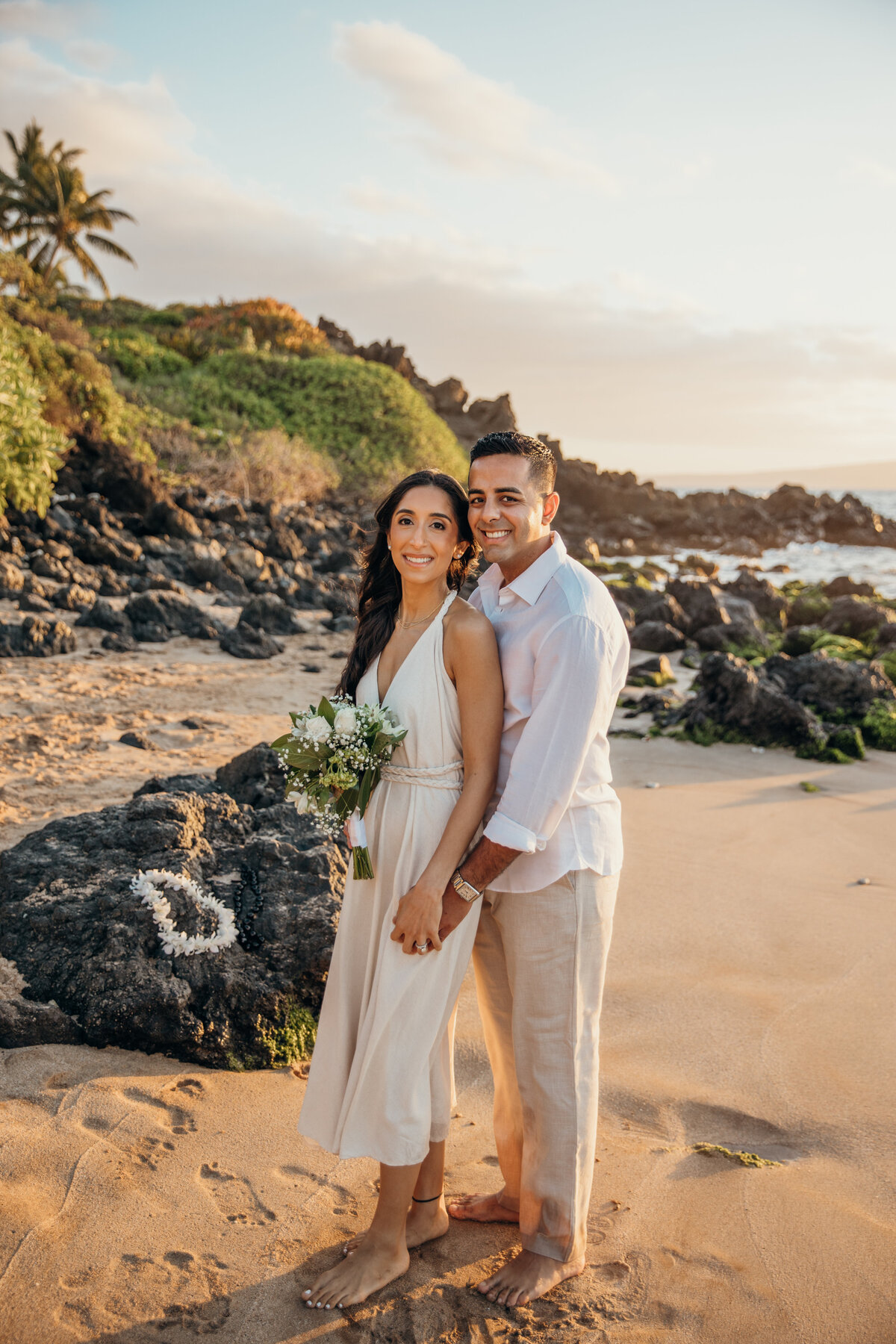 Maui Wedding Photographer captures bride and groom holding hands and smiling on beach