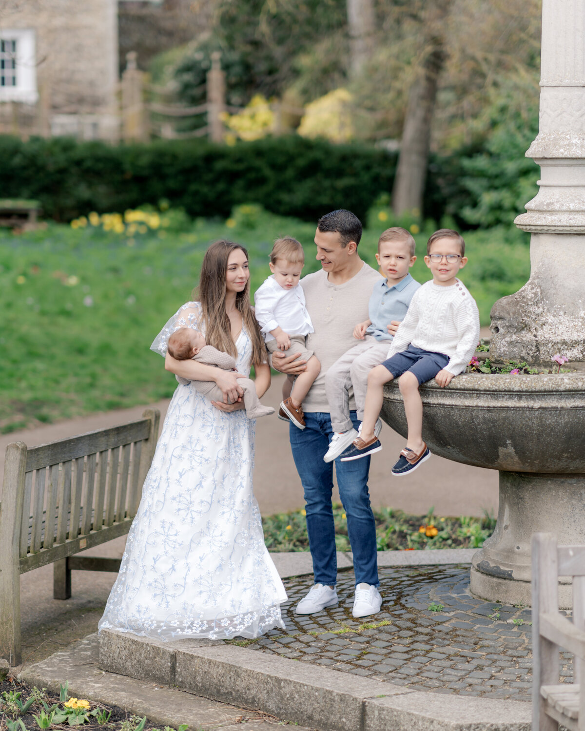 Large family stands next to scultupre in gardens by Savannah family photographer Courtney Cronin