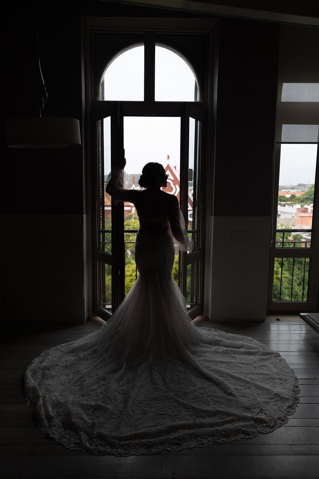 A silhouette of Victoria in her wedding dress, gazing out over the historic Cartagena skyline before saying ‘I do.’