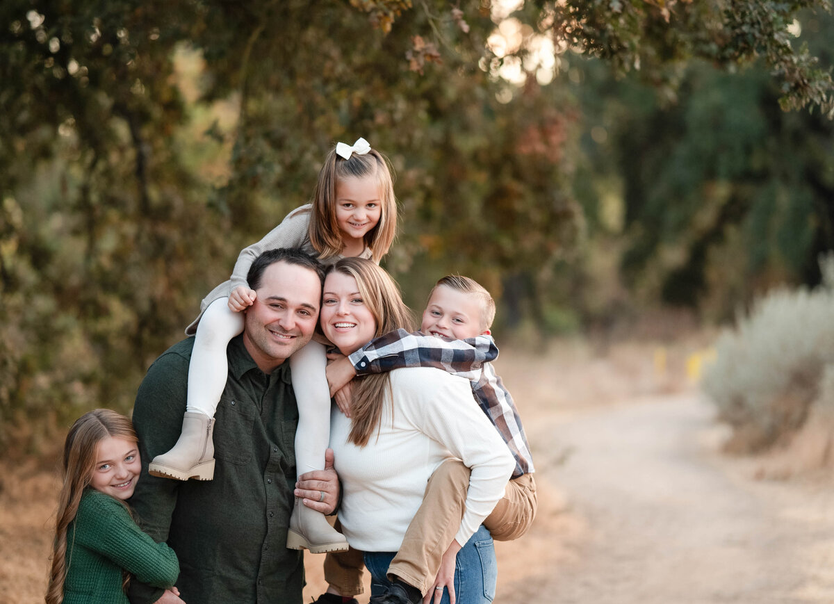 Family all laughing at boy who made a joke in the fields of Oak Grove Park in Ripon, CA
